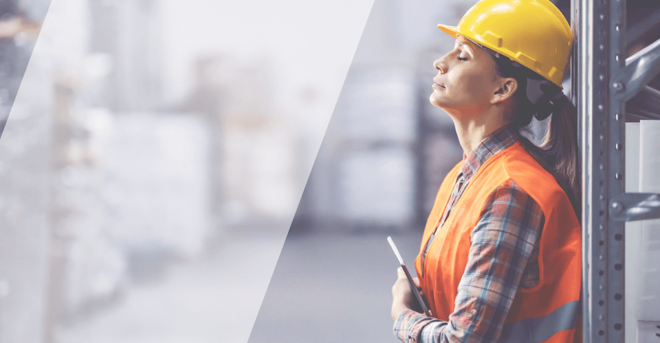 femme portant un casque et un gilet de chantier qui soupire, signes de fatigue